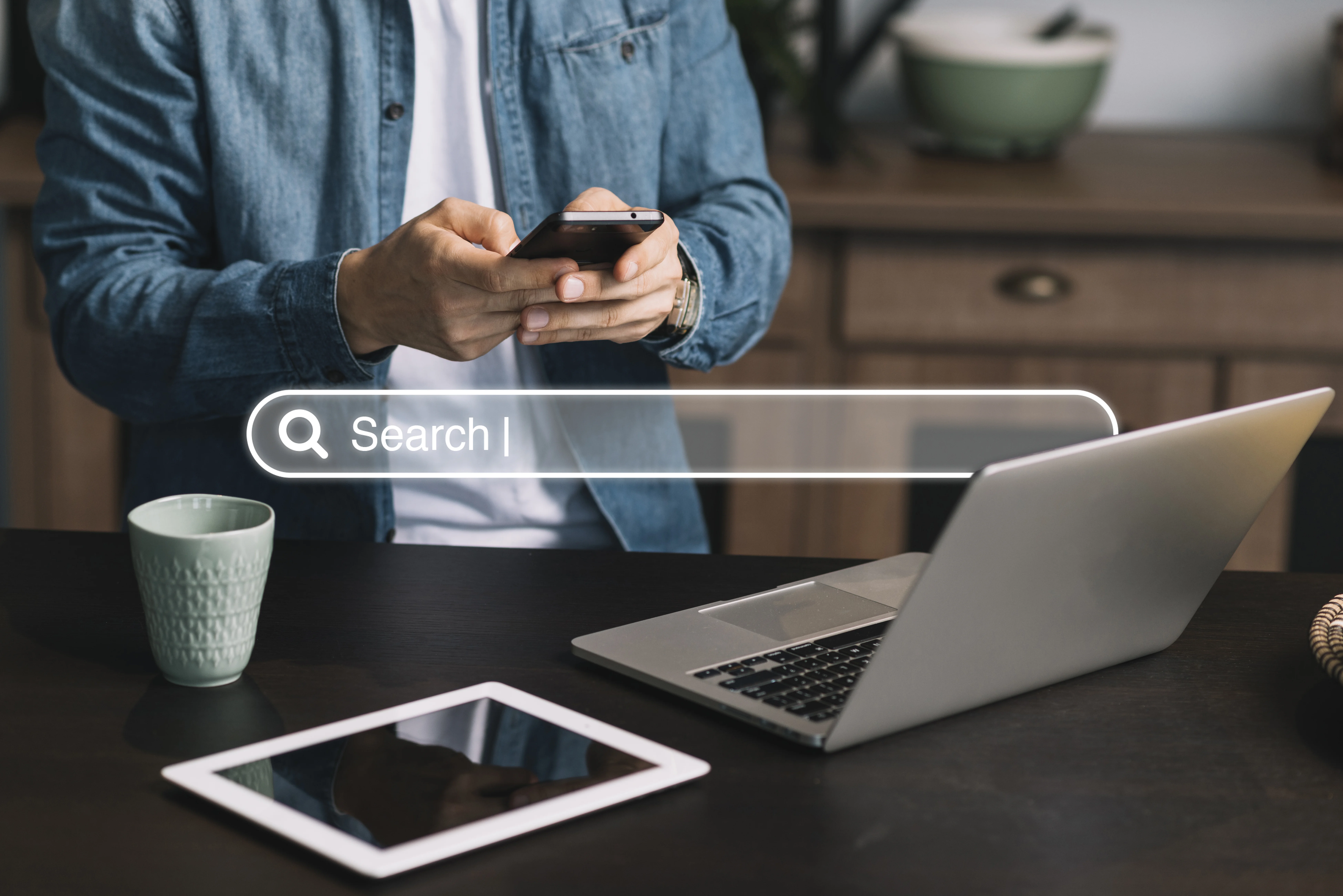un homme utilisant son téléphone avec au première plan une barre de recherche translucide ou il est écrit "search"